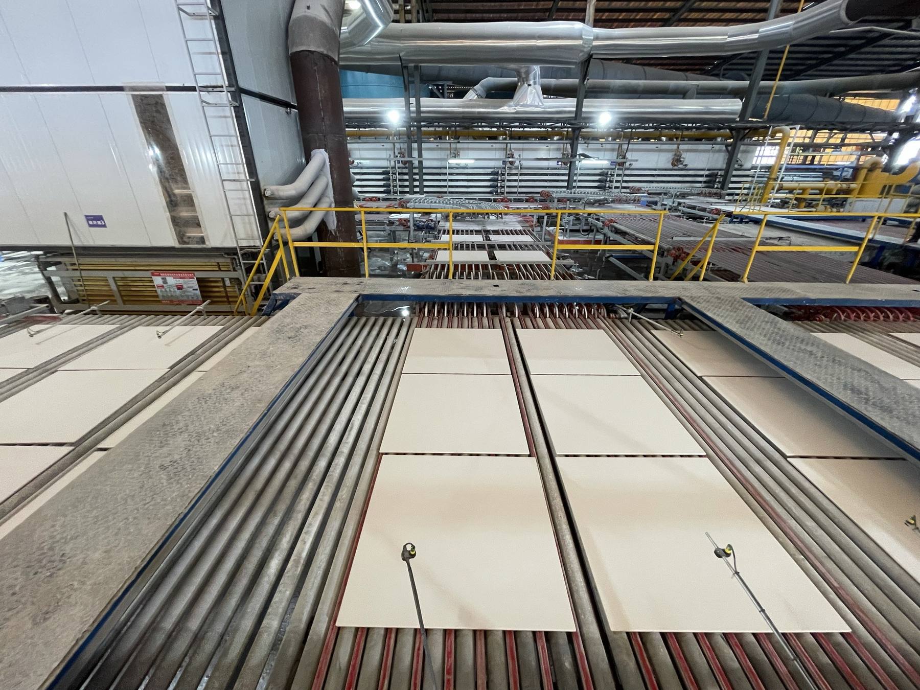 Off-white large-format tiles on roller conveyors at the Chaling plant